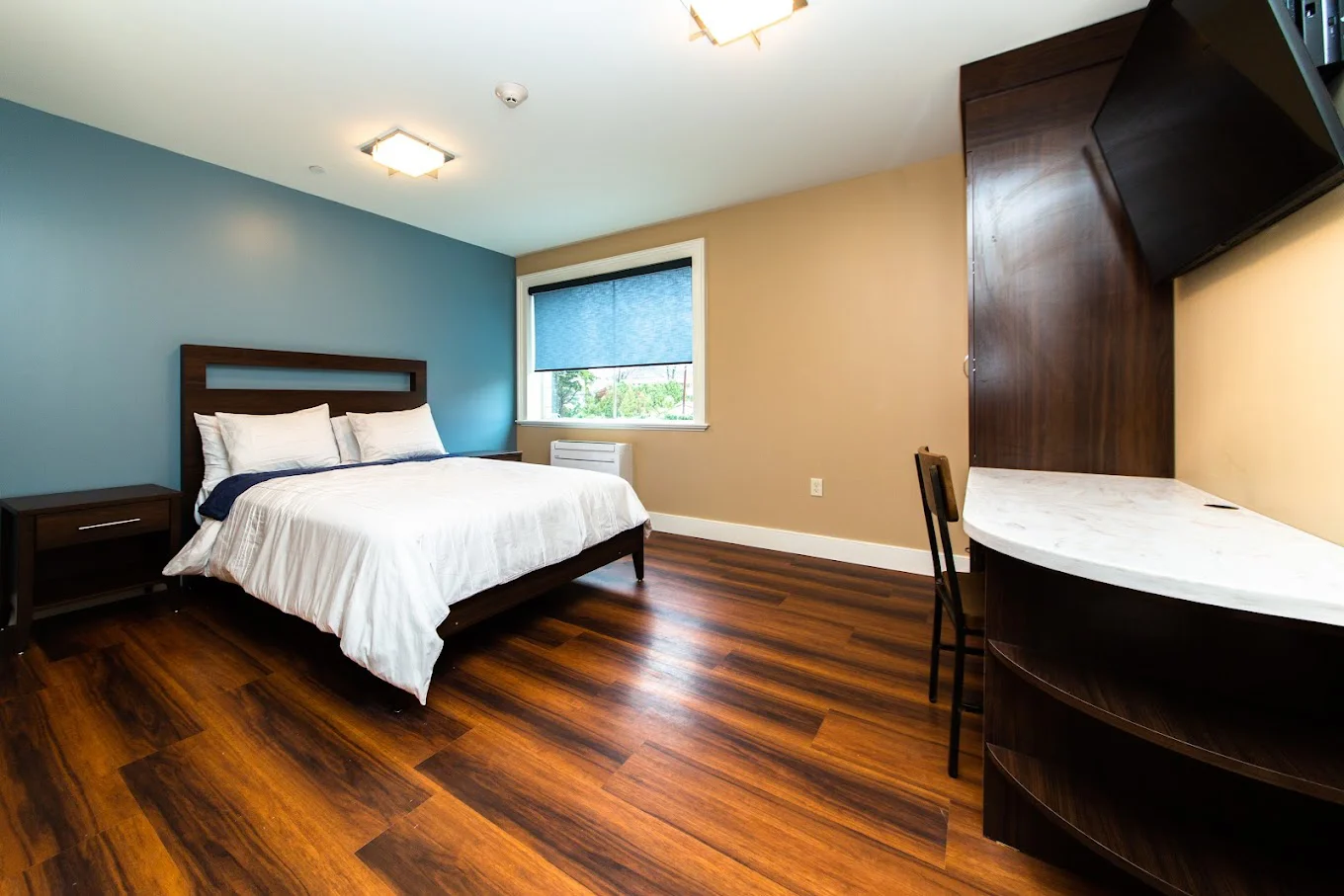 Bedroom with a window, wooden decor and side-table.
