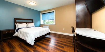 Bedroom with a window, wooden decor and side-table.
