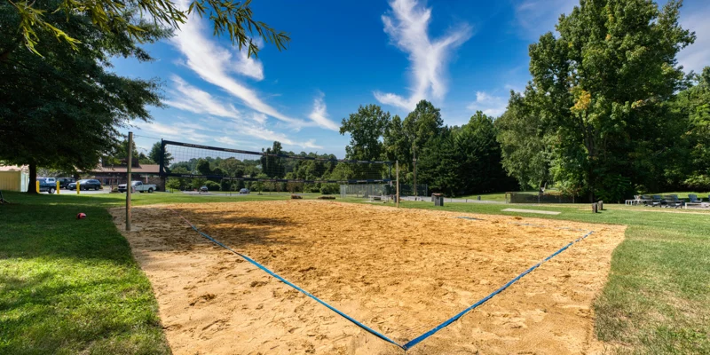 Sand volleyball court on a sunny day with net setup.