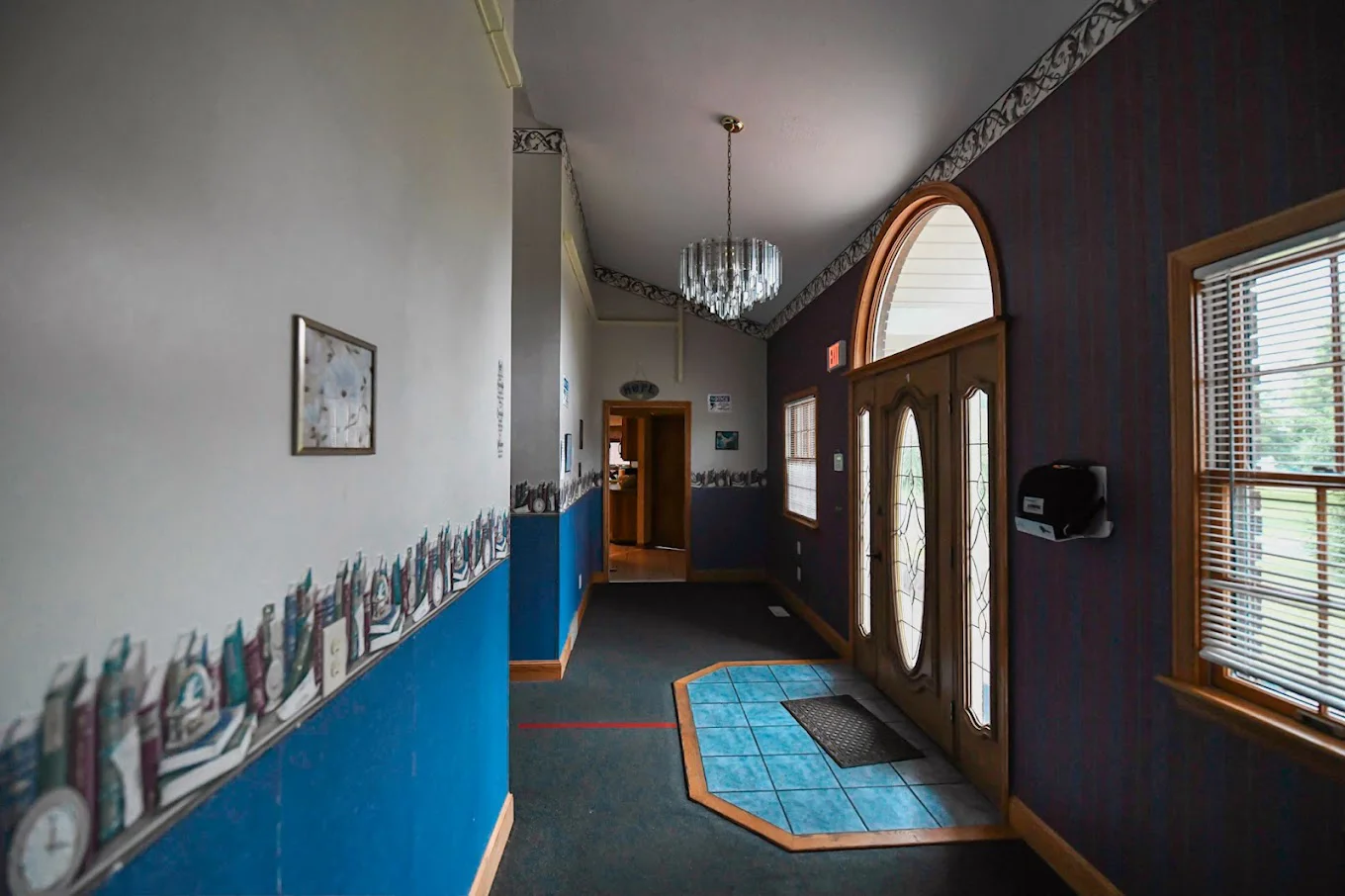 Rehab facility hallway with decorative trim and double glass doors.