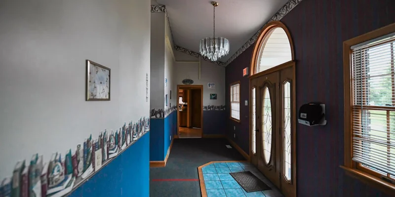 Rehab facility hallway with decorative trim and double glass doors.