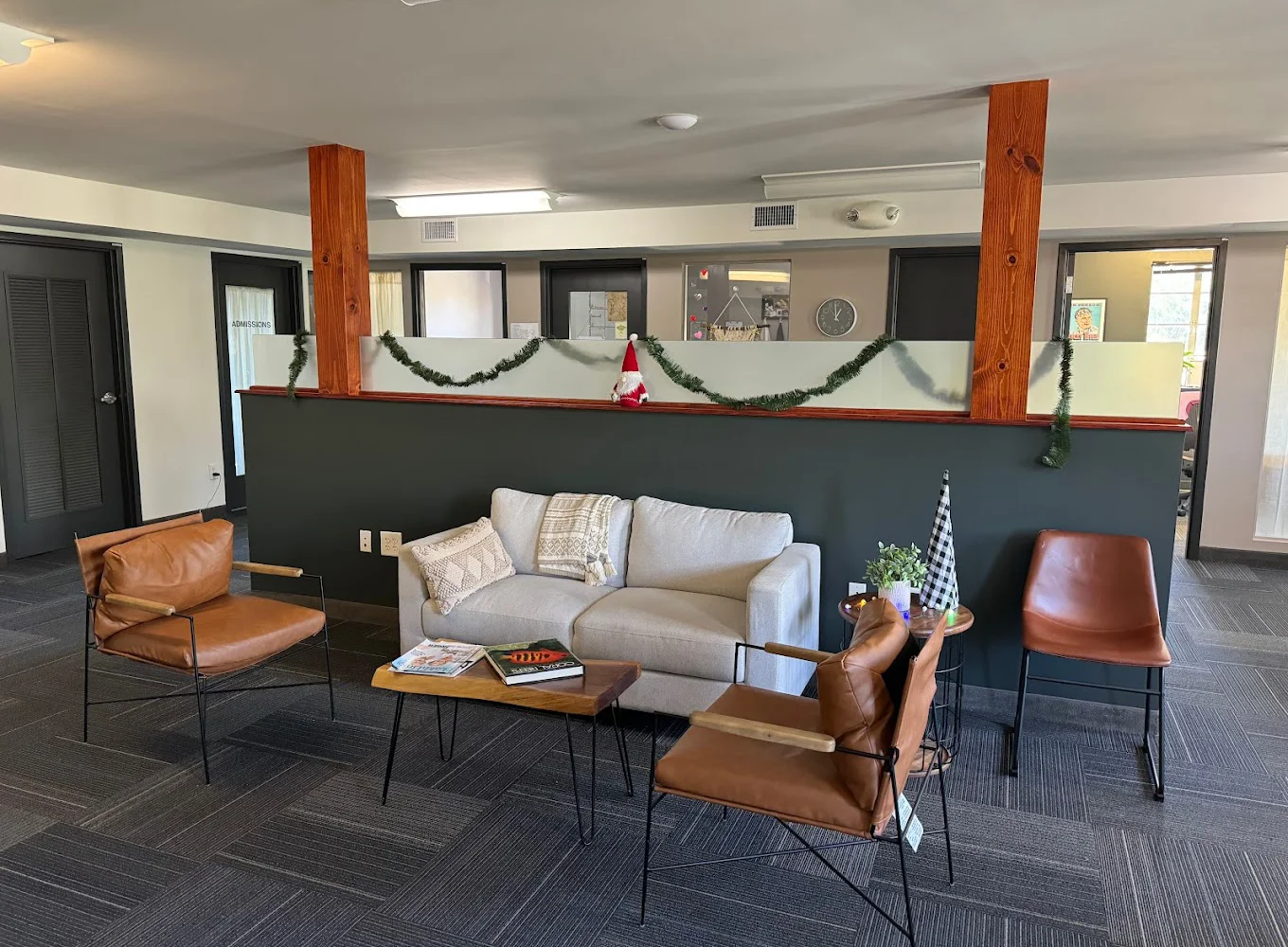 Cozy lounge area with brown leather chairs and a gray sofa.