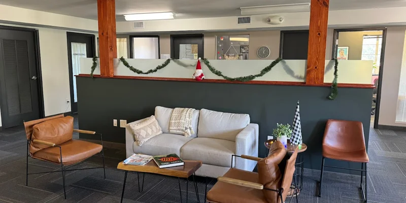 Cozy lounge area with brown leather chairs and a gray sofa.