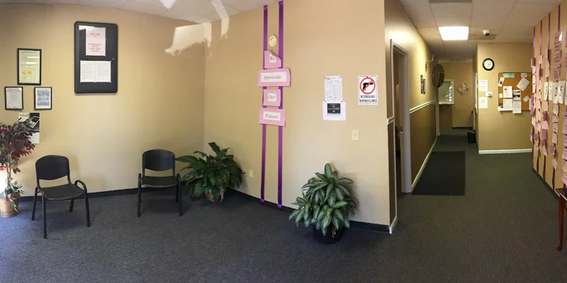 Waiting area with beige walls, chairs, plants, and patient appreciation notes.