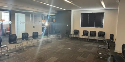 Large group therapy room with black chairs arranged in a circle.