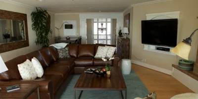 Cozy living room with a leather sectional and mounted TV.