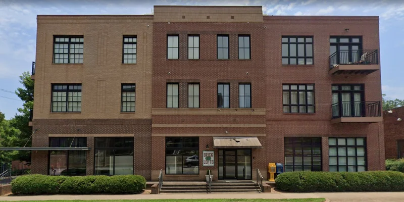 A front view of a modern brick rehab facility with black-framed windows