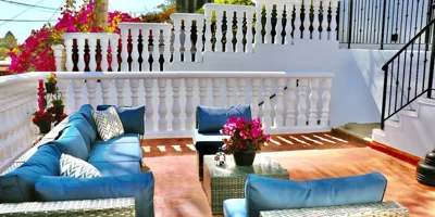 Outdoor patio with blue cushioned seating and potted flowers
