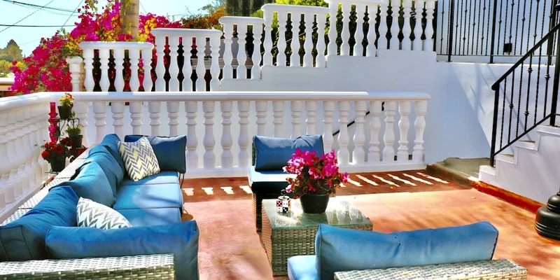 Outdoor patio with blue cushioned seating and potted flowers
