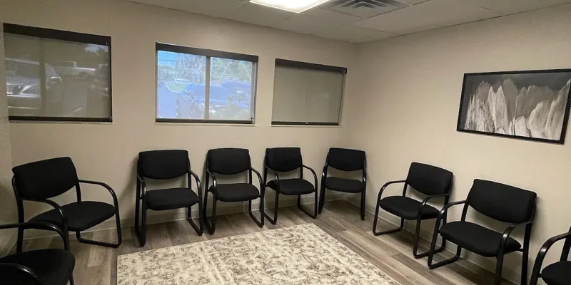 Circle of chairs in a carpeted room with windows