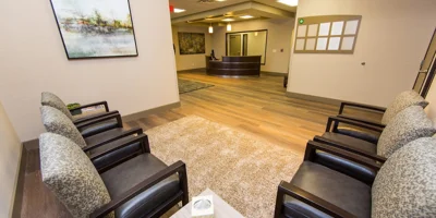 Reception area with a circular front desk and seating area with black chairs