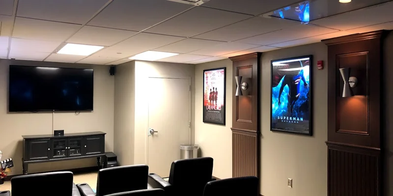Cinema style area with TV and arm-chairs in rows.