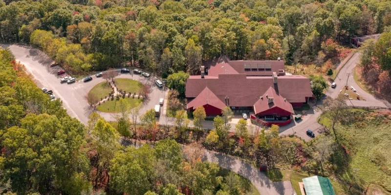 Aerial view of rehab facility with red-roofed buildings and greenery