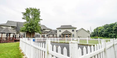 Outdoor fenced-in pool area with a wooden deck and gazebos.