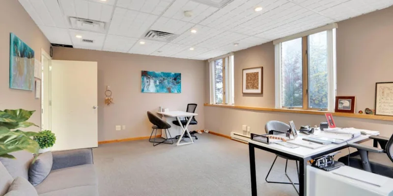 Therapy room with a couch, chairs and desks.
