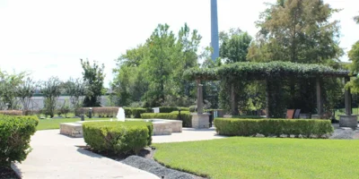 Outdoor garden with a fountain, seating area aroung greenery.