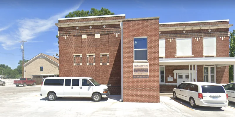 Brick rehab facility with a welcoming entrance, surrounded by a spacious parking area.