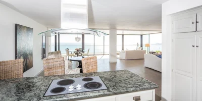 Kitchen with island stove and ocean view in the background.