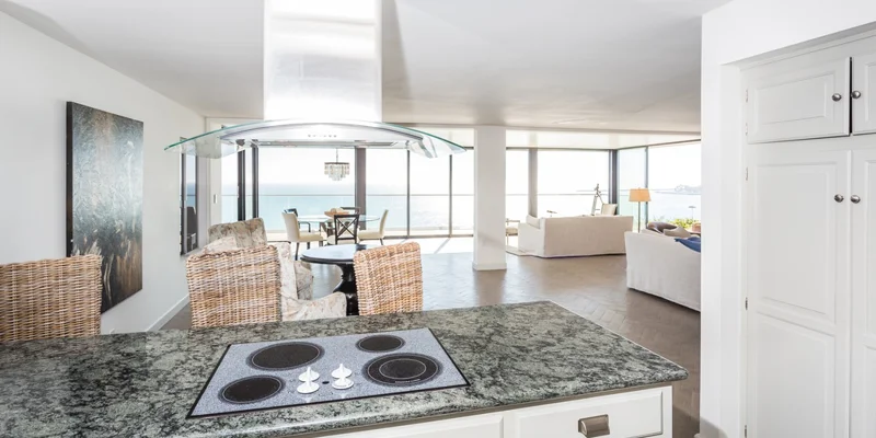 Kitchen with island stove and ocean view in the background.