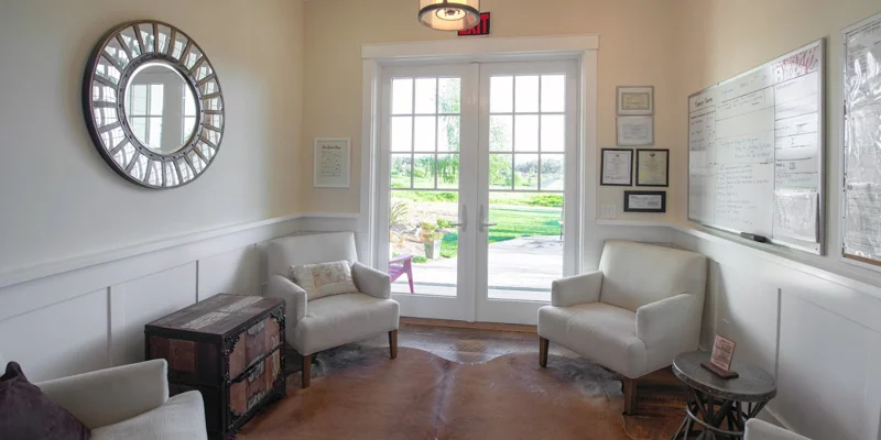 Waiting area with armchairs and side-tables.