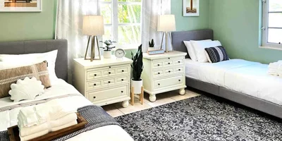 Bright shared bedroom with two twin beds and nightstands.