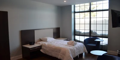 Minimalist bedroom with a large window and modern furnishings.
