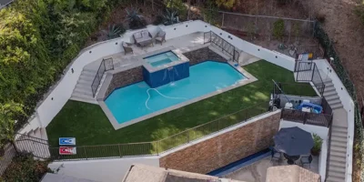 Backyard pool area with a spa and seating.