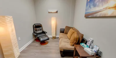 Therapy room with arranged chairs and a whiteboard for sessions.