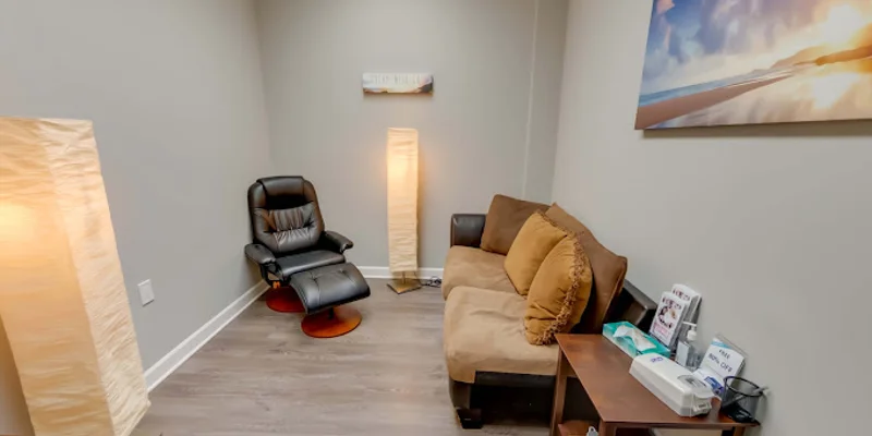 Therapy room with arranged chairs and a whiteboard for sessions.