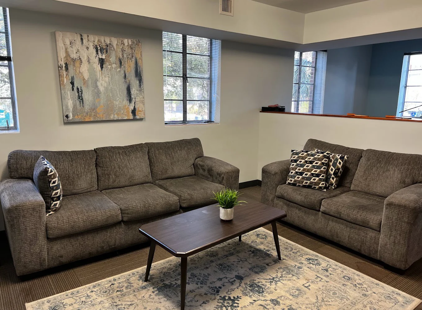 Comfortable lounge space with two gray sofas and modern decor.