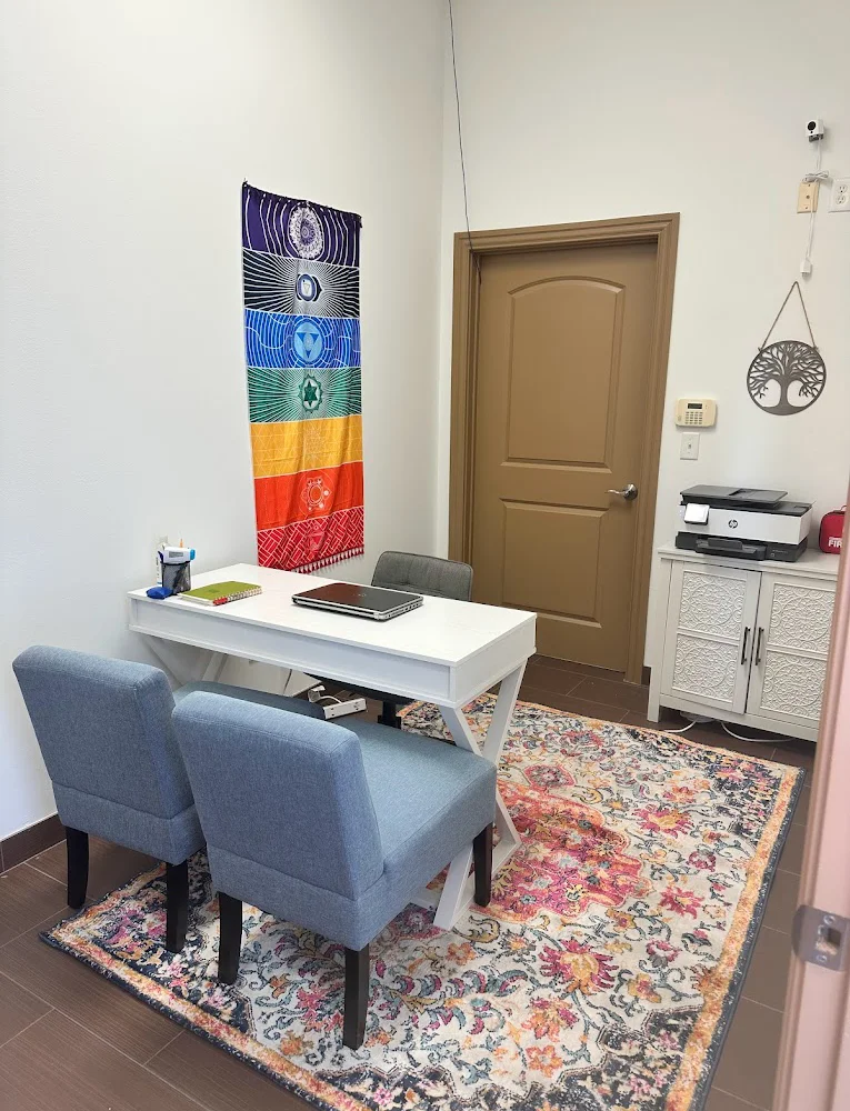 Cozy office space with a white desk and two chairs.