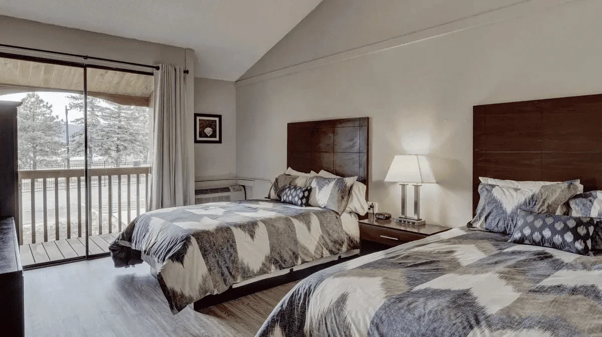 Shared bedroom with two beds and a balcony.