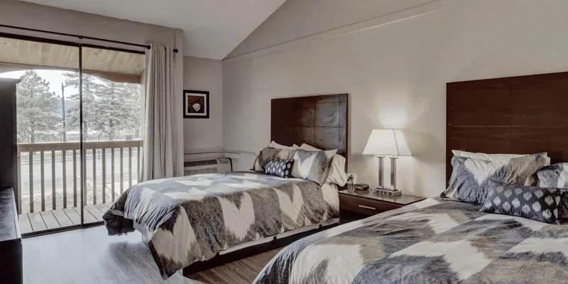 Shared bedroom with two beds and a balcony.
