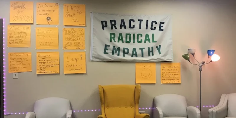 A therapy room with a "Practice Radical Empathy" banner on the wall
