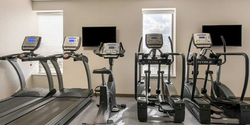 A well-equipped gym with treadmills, ellipticals, and exercise bikes.