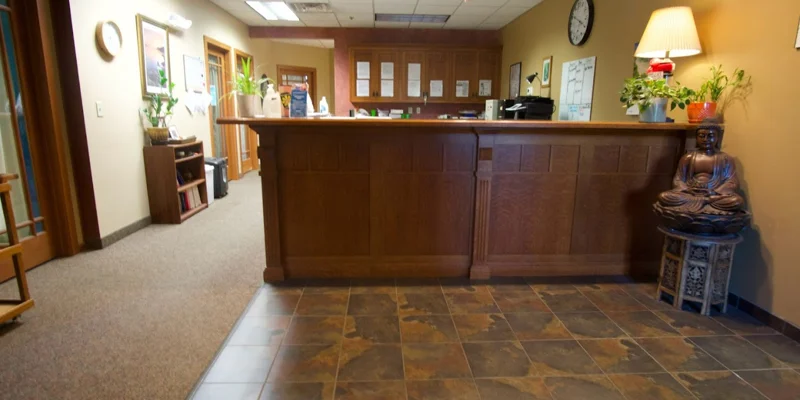 A warm-toned reception area with a wooden counter and décor