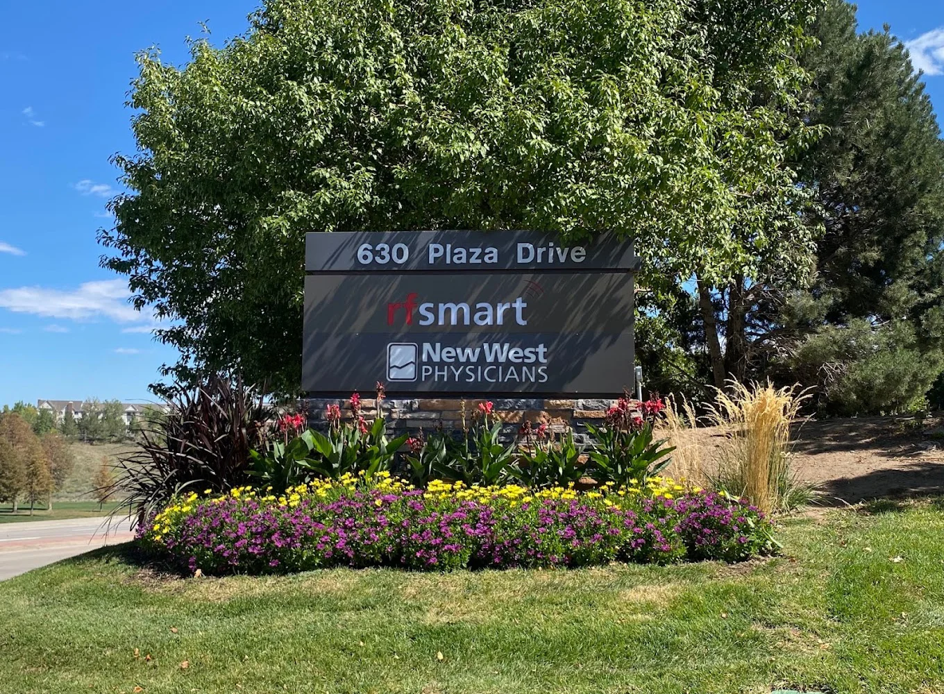 Outdoor sign for a medical office surrounded by greenery.