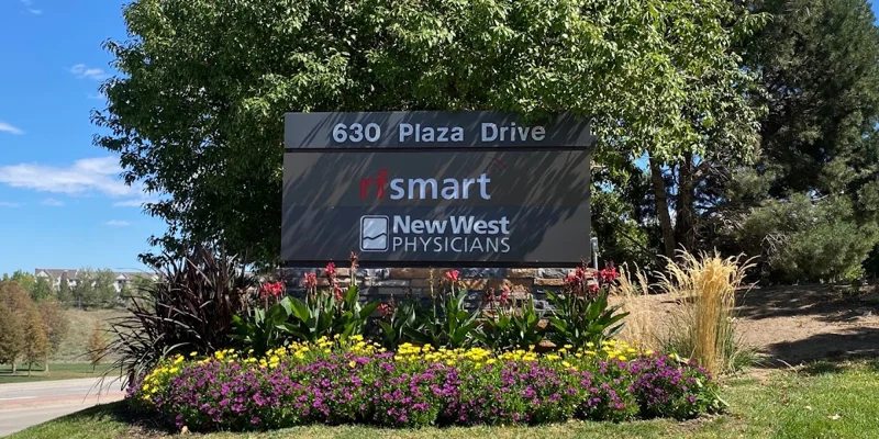 Outdoor sign for a medical office surrounded by greenery.