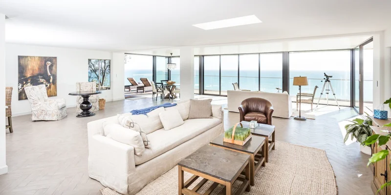 Living area with couches and large windows.
