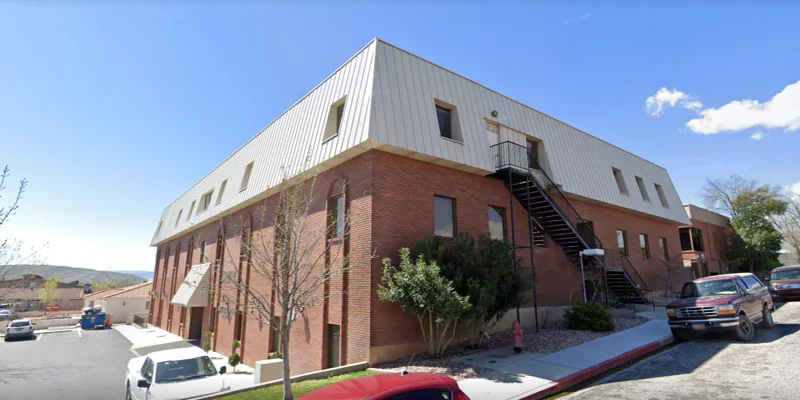 Three-story brick building with a white upper level and an exterior staircase.