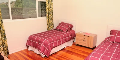 Bedroom with two twin beds and a ceiling fan.