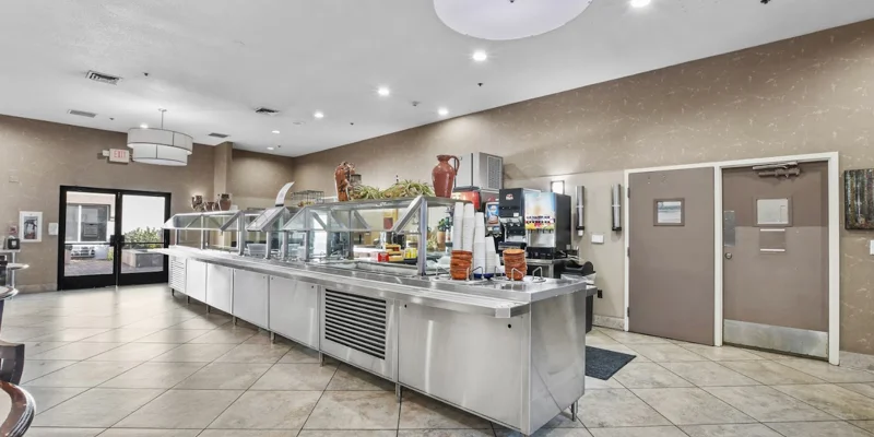 Modern cafeteria with stainless steel counters and food stations