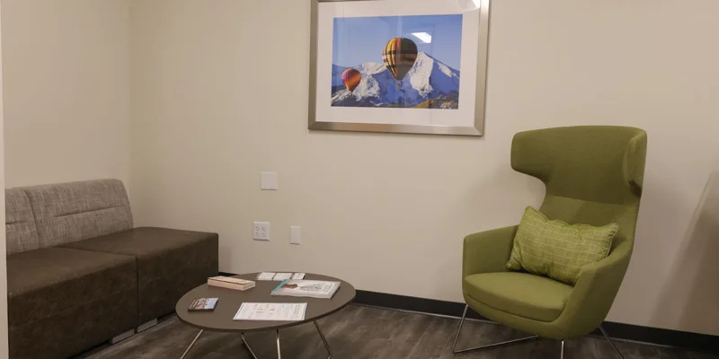 Therapy room with green and brown seating and a framed artwork.
