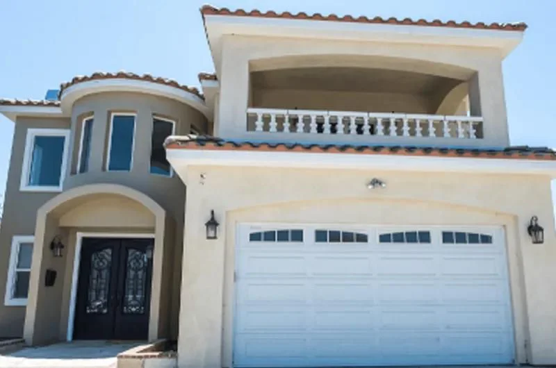 Facility exterior with a balcony, garage and entrance.