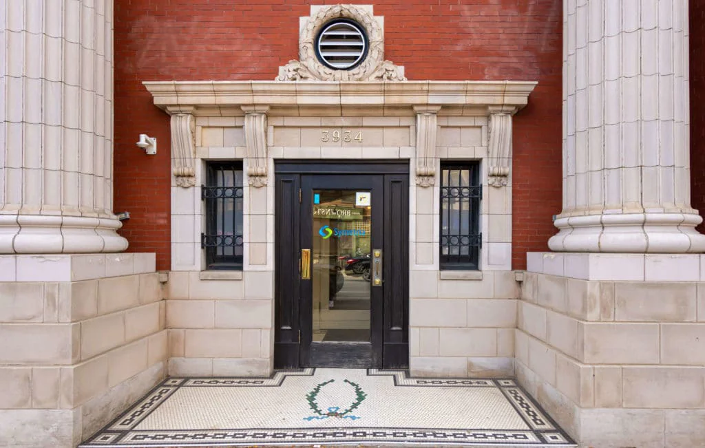 Historic brick building entrance with columns.
