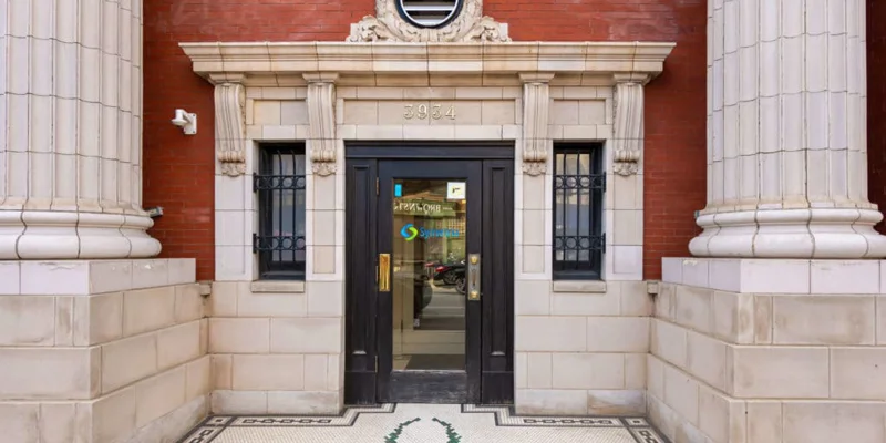 Historic brick building entrance with columns.