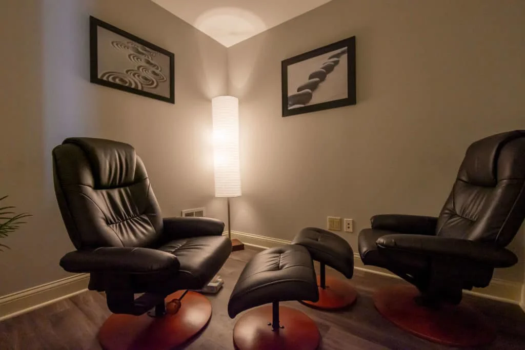 Therapy room with reclining chairs and soft lighting.