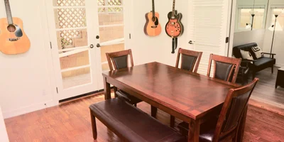 Dining area with a wooden table and guitars on the wall.