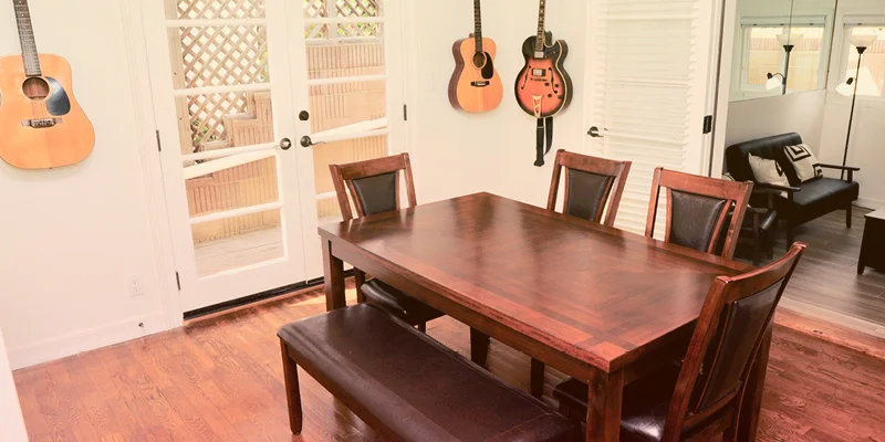 Dining area with a wooden table and guitars on the wall.