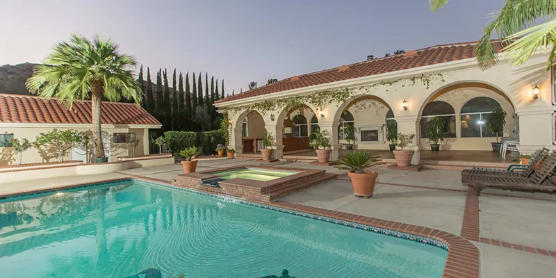 Backyard with a pool, hot tub and seating.